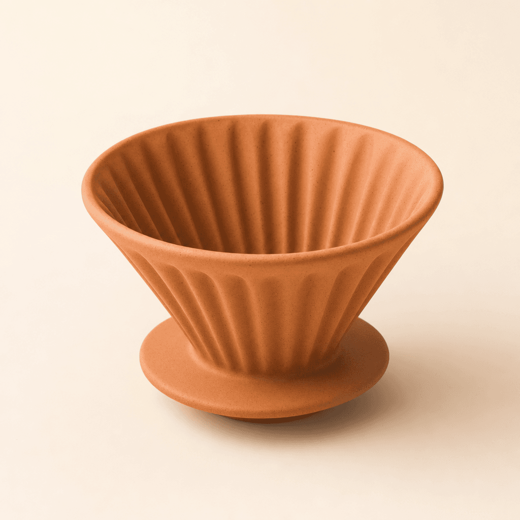 Matte clay ceramic pour-over dripper on a cream surface